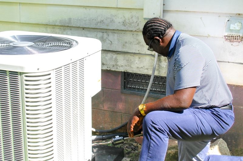 Groundswell partner examines an air conditioner