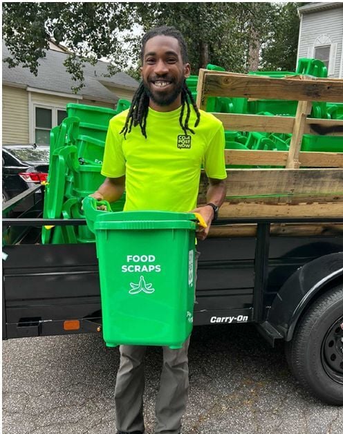 compostnow employee holding a food scraps bin